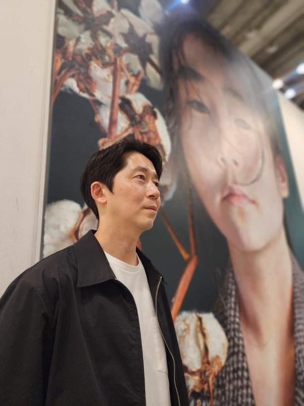 Kang Kang-hoon is seen in this photo with a giant portrait of his daughter at the BEXCO exhibition center in Busan, 320 kilometers southeast of Seoul, on May 10, 2024. (Yonhap)